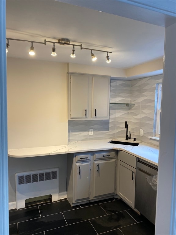 kitchen with dishwasher, sink, white cabinetry, decorative backsplash, and radiator