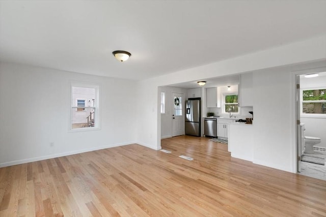 691 Beacon St, Lowell, MA 01850 - unfurnished living room featuring light wood finished floors and plenty of natural light