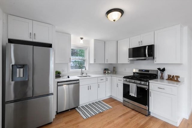691 Beacon St, Lowell, MA 01850 - kitchen with stainless steel appliances, white cabinetry, light countertops, and light wood-type flooring