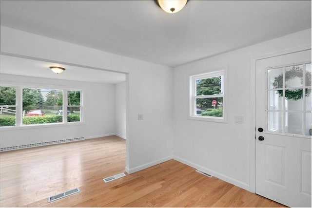 691 Beacon St, Lowell, MA 01850 - entrance foyer featuring a baseboard heating unit and light wood-style flooring