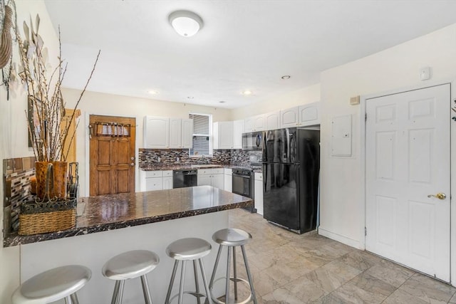 kitchen with a breakfast bar area, white cabinetry, a peninsula, and black appliances