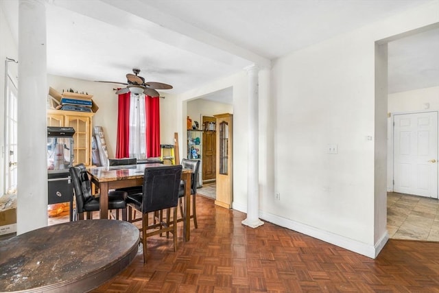 dining space with decorative columns, baseboards, and a ceiling fan