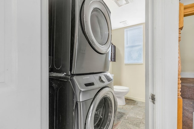 washroom featuring tile patterned floors and stacked washer / drying machine