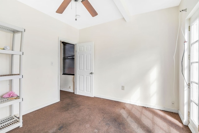 carpeted spare room featuring beamed ceiling and ceiling fan