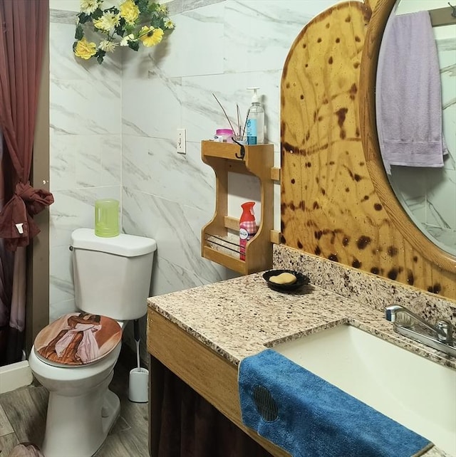 bathroom with toilet, wood finished floors, and vanity