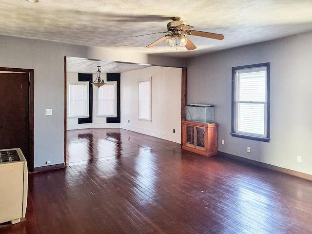 unfurnished living room with wood-type flooring, baseboards, ceiling fan, and a textured ceiling