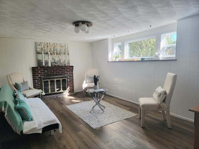 sitting room featuring a fireplace, a textured ceiling, and wood finished floors