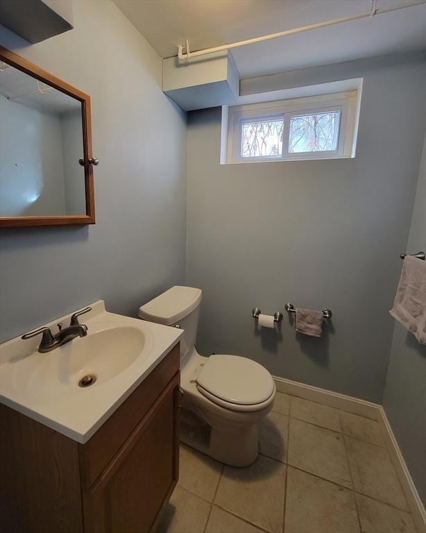 bathroom with tile patterned floors, baseboards, toilet, and vanity