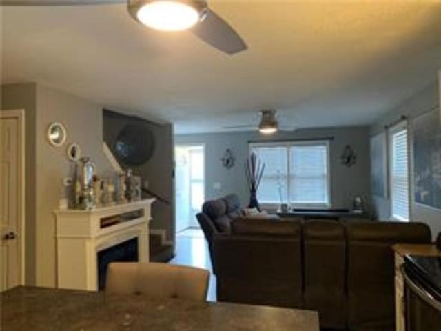 living room with ceiling fan, a fireplace, and plenty of natural light