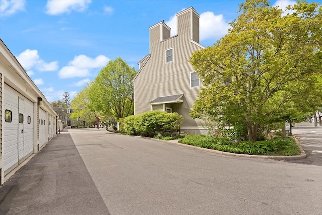 view of asphalt road featuring community garages