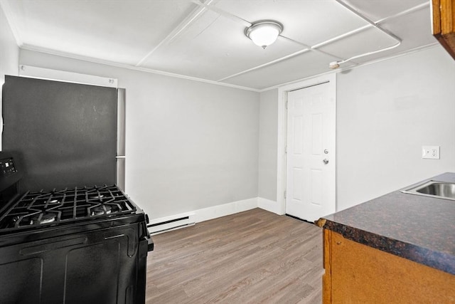 48-50 Portland St, Haverhill, MA 01830 - kitchen featuring black range with gas cooktop, wood finished floors, a baseboard radiator, and dark countertops