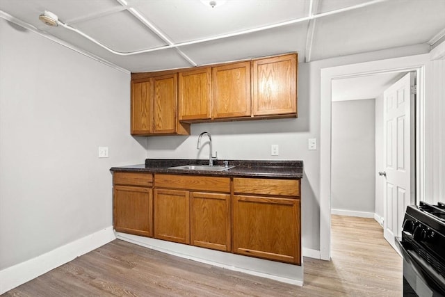 48-50 Portland St, Haverhill, MA 01830 - kitchen featuring black gas stove, brown cabinets, light wood-style flooring, and dark stone countertops