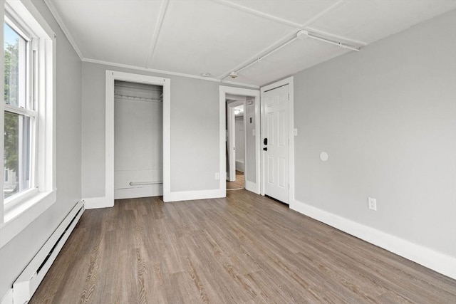 48-50 Portland St, Haverhill, MA 01830 - unfurnished bedroom with a baseboard radiator, wood finished floors, multiple windows, and a closet