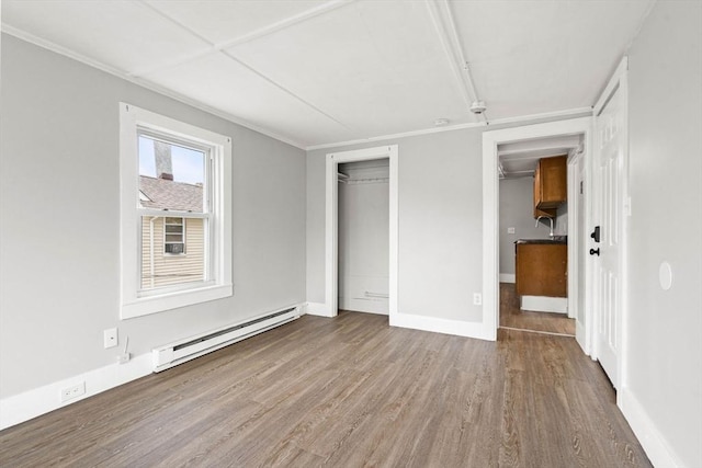 48-50 Portland St, Haverhill, MA 01830 - unfurnished bedroom featuring a baseboard radiator, wood finished floors, and a closet