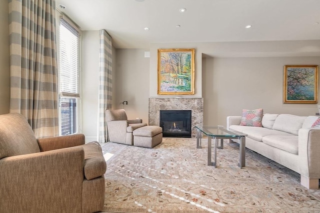 living room featuring a premium fireplace and recessed lighting