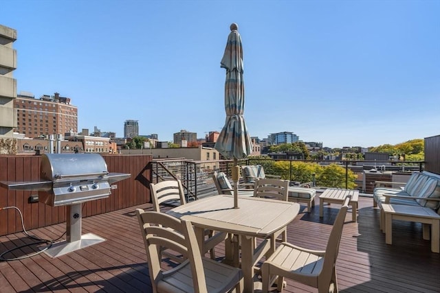 wooden terrace featuring a grill and a city view