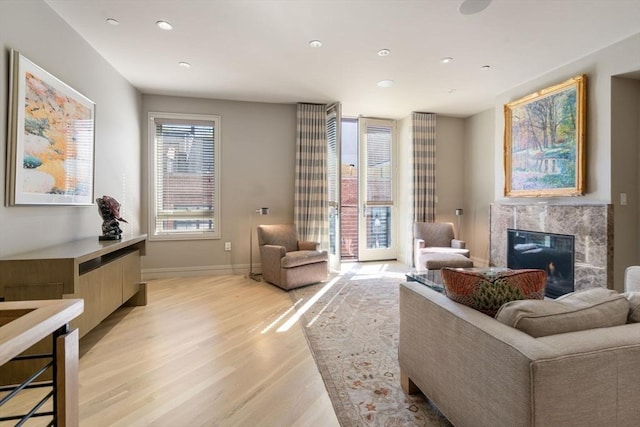 interior space featuring light wood-type flooring, a fireplace, baseboards, and recessed lighting