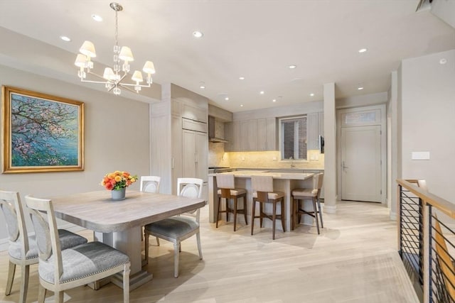 dining space featuring baseboards, light wood-style floors, an inviting chandelier, and recessed lighting
