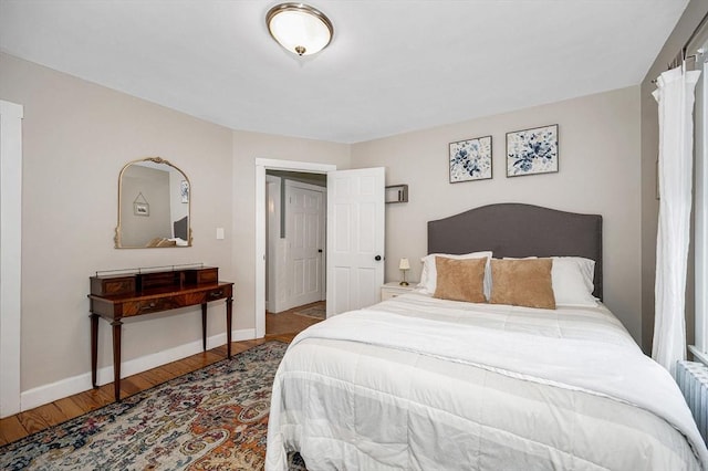 bedroom featuring hardwood / wood-style flooring and radiator