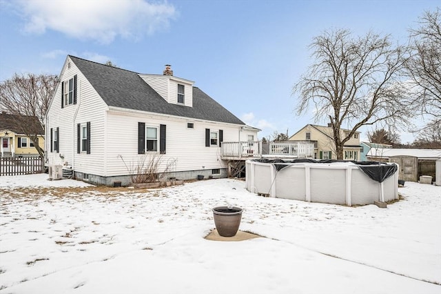 snow covered property with a swimming pool side deck