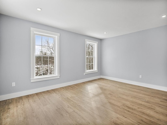 spare room with plenty of natural light and light hardwood / wood-style flooring