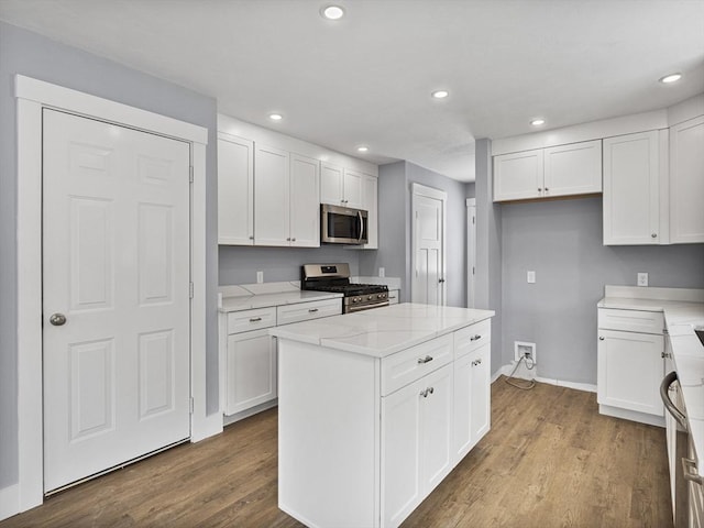 kitchen featuring stainless steel appliances, a center island, white cabinets, and light hardwood / wood-style floors