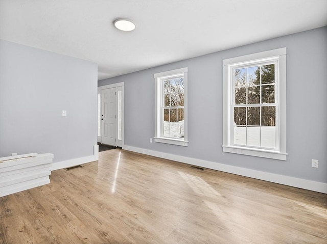 unfurnished room featuring plenty of natural light and light wood-type flooring