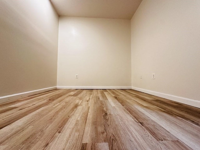 spare room featuring light wood finished floors and baseboards