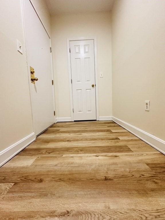 doorway to outside featuring light wood-style flooring and baseboards