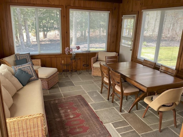 sunroom / solarium with wood walls and stone finish flooring