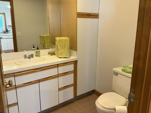 half bath featuring toilet, tile patterned floors, and vanity