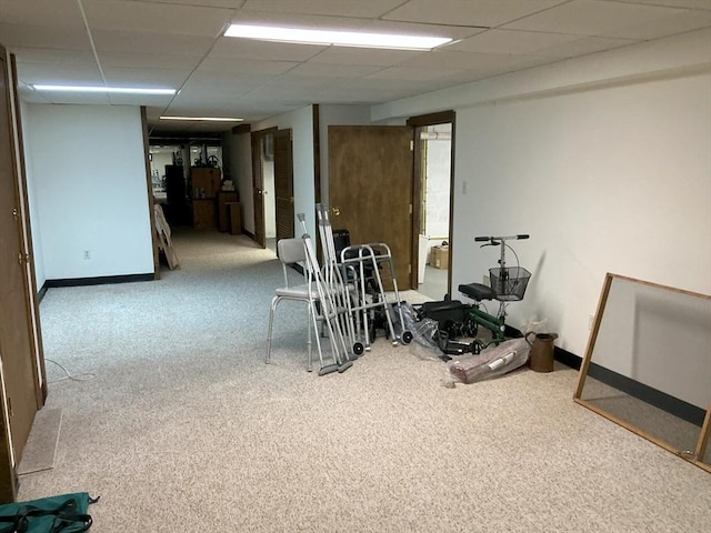 interior space featuring baseboards, a paneled ceiling, and carpet