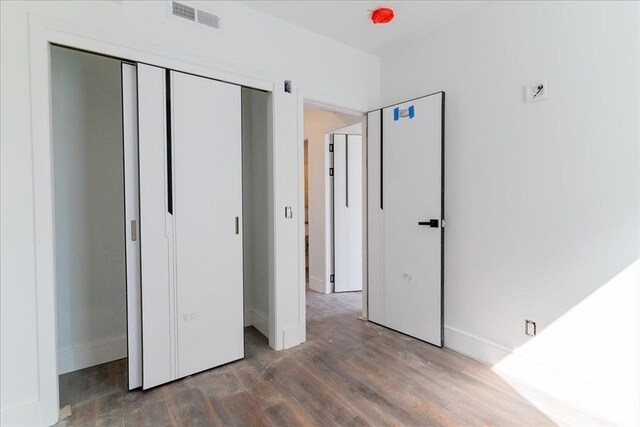 29 Woodford St Unit 2, Boston, MA 02125 - unfurnished bedroom with wood finished floors, baseboards, and a closet