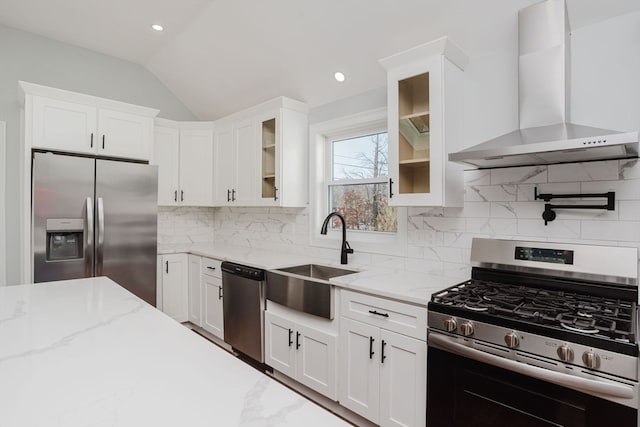 kitchen with light stone countertops, sink, wall chimney exhaust hood, stainless steel appliances, and backsplash