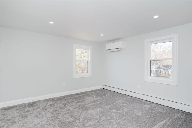 carpeted spare room featuring a baseboard radiator, an AC wall unit, and a wealth of natural light