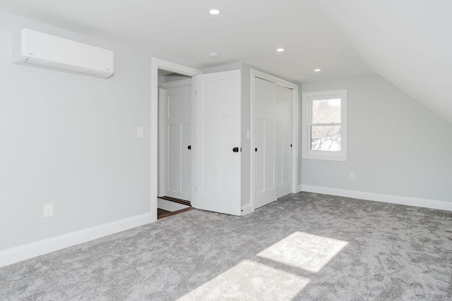 interior space featuring carpet floors, a wall mounted AC, and lofted ceiling