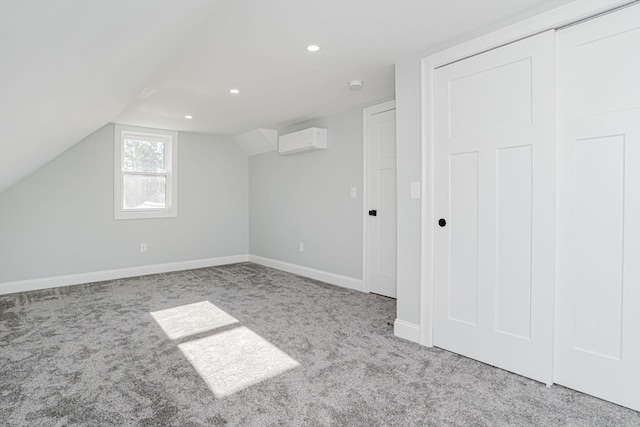 additional living space featuring light carpet, vaulted ceiling, and an AC wall unit