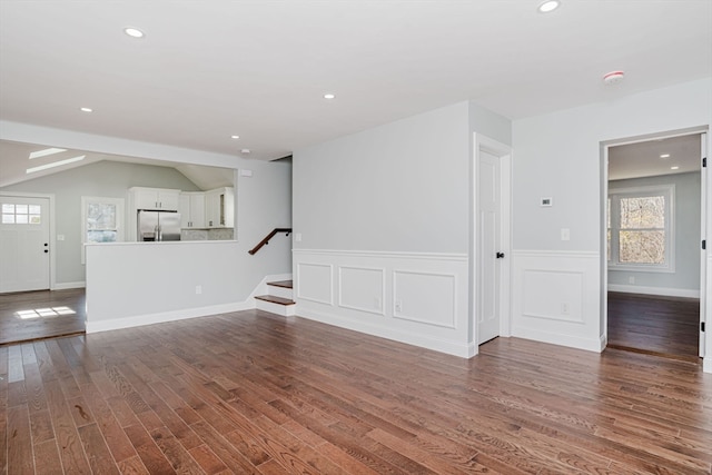 unfurnished living room featuring hardwood / wood-style floors and lofted ceiling