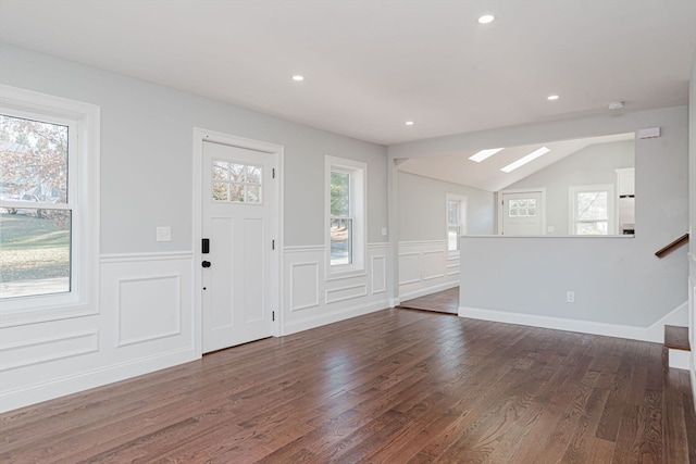 foyer featuring dark hardwood / wood-style floors and vaulted ceiling with skylight