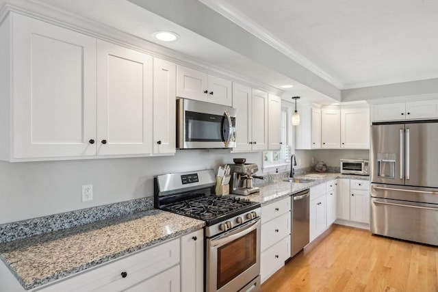 kitchen with white cabinets, stainless steel appliances, a toaster, and a sink