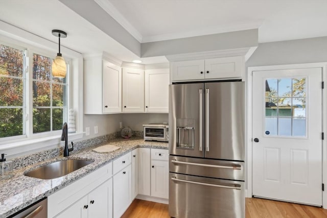 kitchen with white cabinetry, stainless steel appliances, light wood-style flooring, and a sink