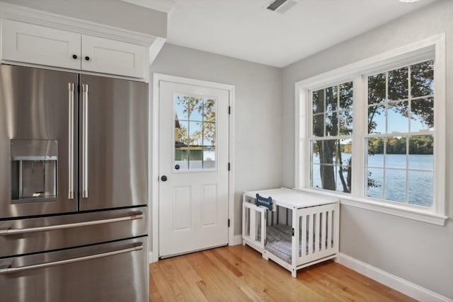 doorway featuring visible vents, plenty of natural light, and baseboards