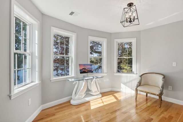 unfurnished room featuring visible vents, a chandelier, and plenty of natural light