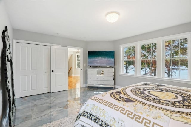 bedroom featuring marble finish floor, multiple windows, a closet, and baseboards