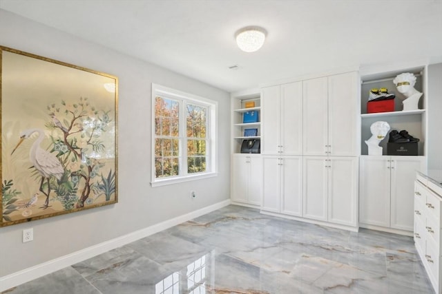 unfurnished bedroom with baseboards and marble finish floor