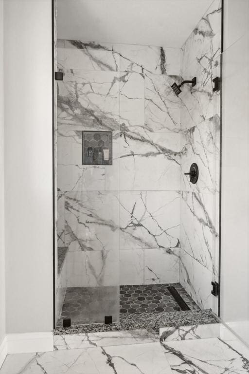 bathroom featuring marble finish floor and a marble finish shower