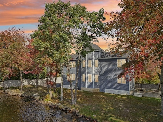 view of property exterior featuring a yard and fence