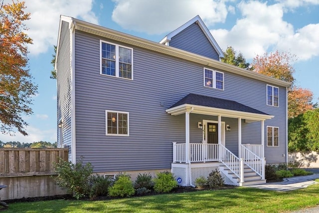 view of front of property with fence, a porch, and a front yard