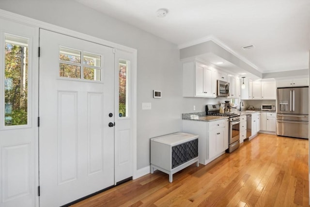 kitchen featuring appliances with stainless steel finishes, light wood-type flooring, and plenty of natural light