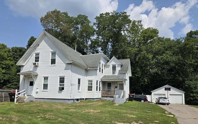 view of front of home featuring a porch, a garage, an outdoor structure, a front lawn, and cooling unit